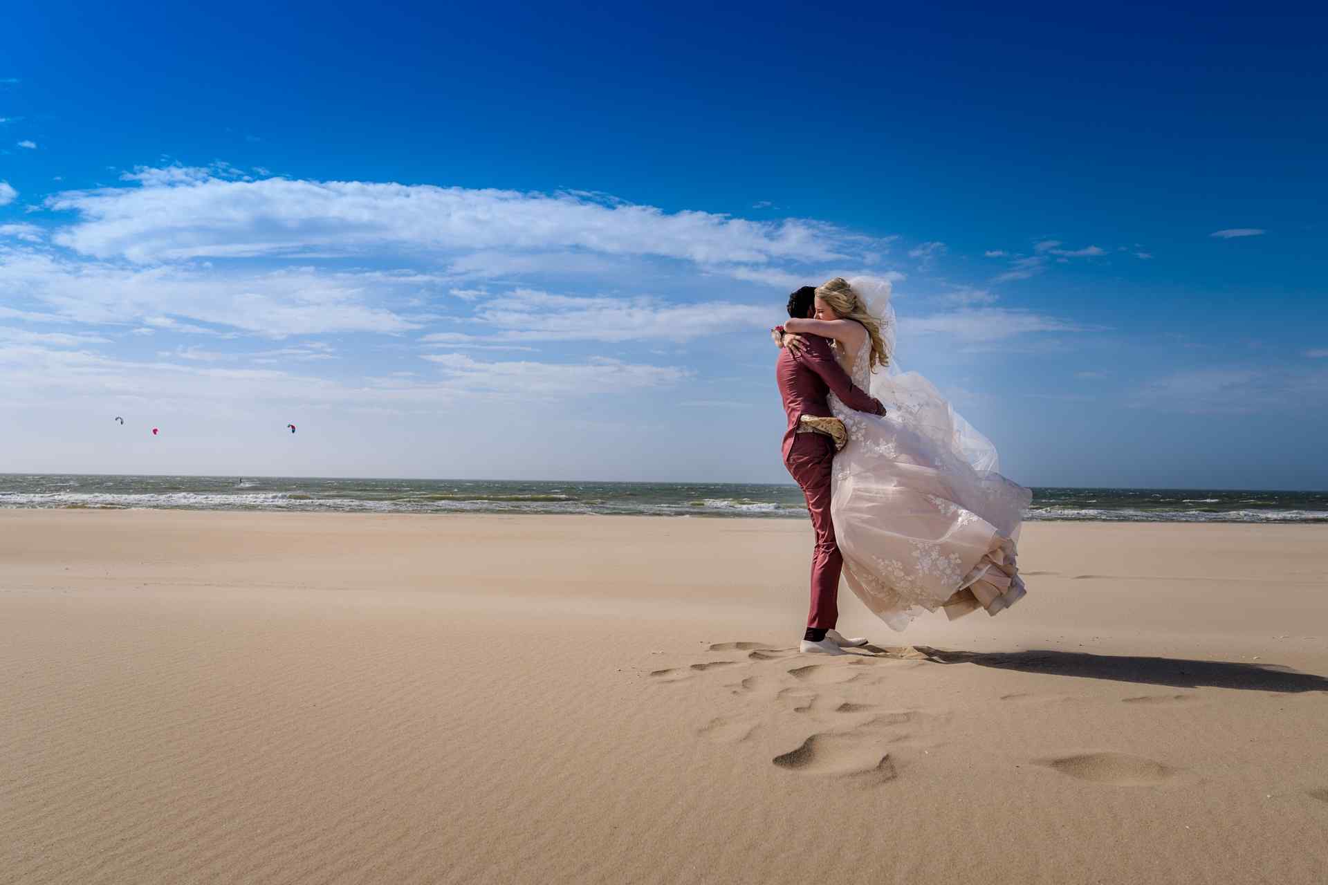 Bruiloft Kijkduin strand optillen bruid