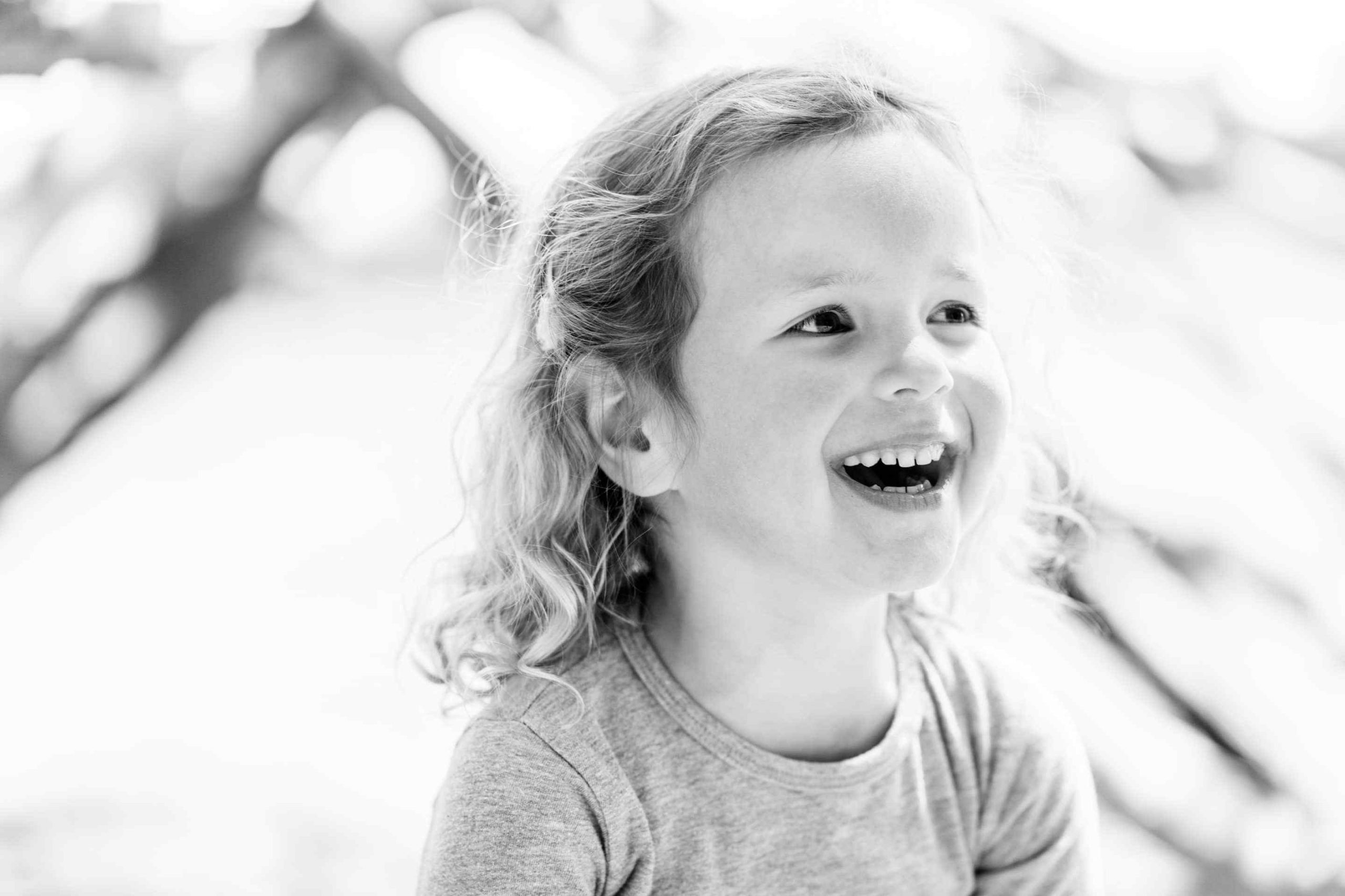 Portret zwart-wit meisje lachend door kinderfotograaf Grietje Mesman